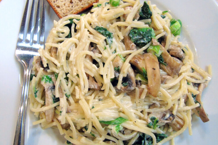 Mushroom noodles with spinach and creme fraiche on plate