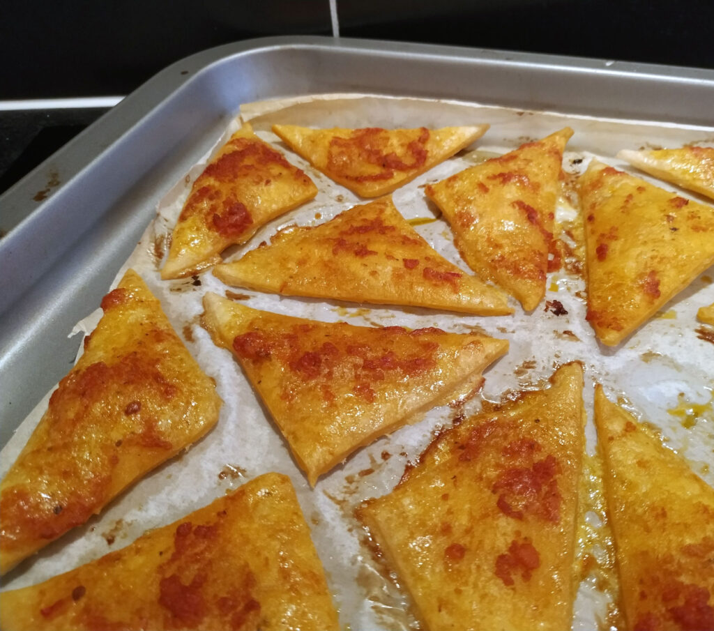 Baked puff pastry triangles with red pesto